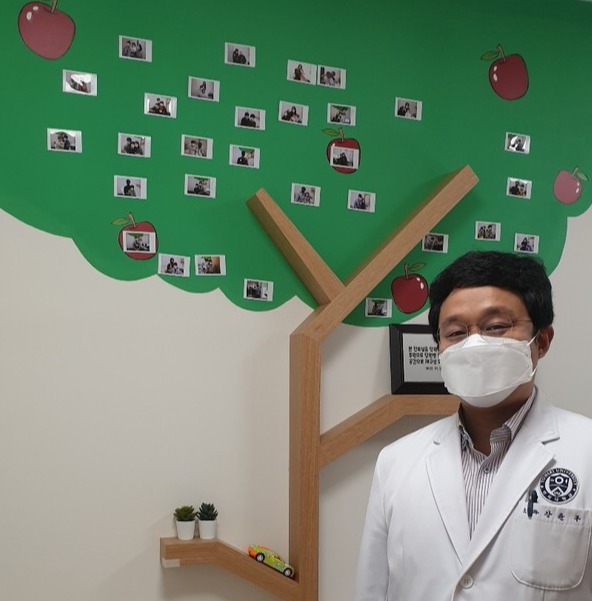 원주세브란스병원 소아청소년과 강윤구 교수 진료실에 그려진 사과나무에 당원병 환자들이 사진이 부착돼 있다.