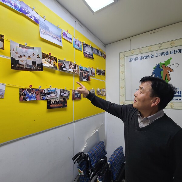 박한진 회장이 벽에 붙어있는 사진들을 바라보며 코헴회 사업들을 소개하고 있다.